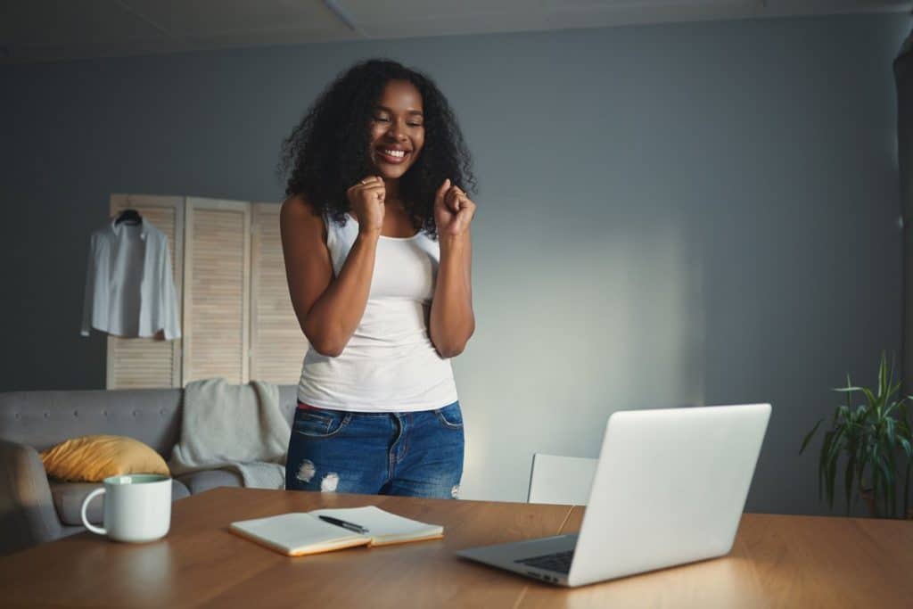 Mujer frente a un ordenador portátil motivada para estudiar